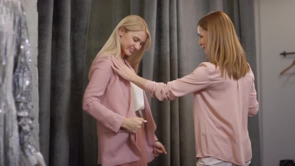 Sequence of Happy Mother Taking Photos of her Adult Daughter at Clothes Store alt
