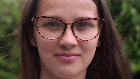 Happy Young European Woman in Glasses Outside Looking at Camera
