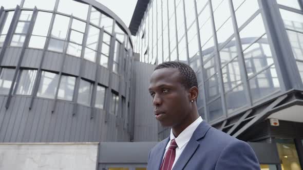 young black businessman in the street looks up,thinking future alt