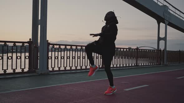 Sporty African American Guy Warming Up and Start Run Workout on City Bridge Training in Evening alt