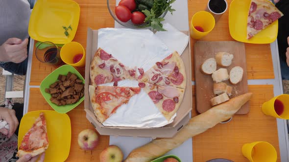 Top View of Hands Taking Pizza Cuts From Box