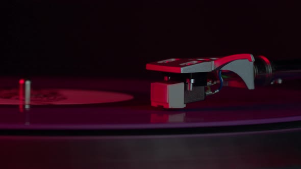 Blue Vinyl Record Spinning on Turntable On Neon Red Light LP Player in Motion