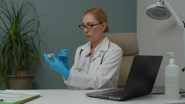 Female Doctor in Protective Gloves Filling Syringe with Vaccine Indoor alt