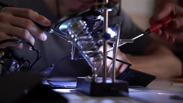Skill Apprentice Working with Soldering Iron at His Working Place. Unrecognized Employee or alt