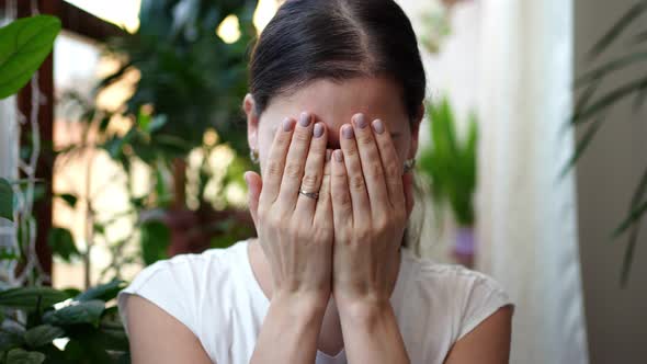 Young Sad Ukrainian Girl with the Flag of Ukraine and Russia on Her Face is Opening Her Eyes alt