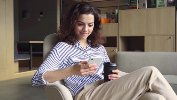 Hispanic Latin Young Girl Student Holding Smartphone and Coffee in Modern Space alt