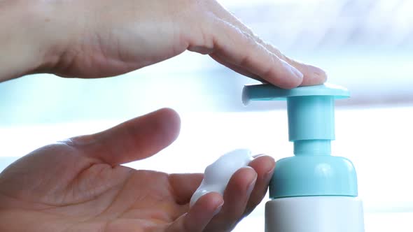 Male Hands Push the Dispenser and Squeeze Out Liquid Soap