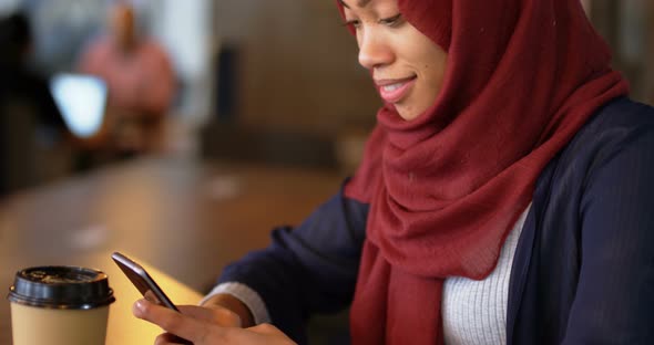 Woman using mobile phone in cafeteria 4k alt