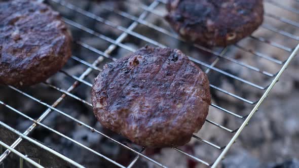 Beef Burgers Cutlets are Roasting on the Charcoal Barbecue Grill alt