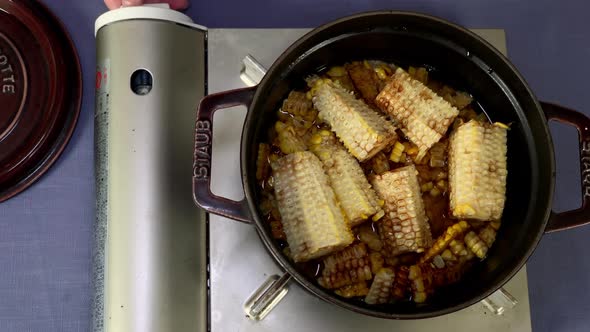 A Japanese female chef cooks rice with grilled kernels at her home kitchen, Tokyo, Japan. July 2019. alt