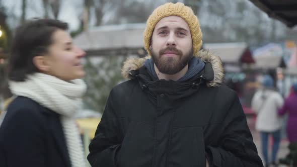 Portrait of Handsome Caucasian Man Waiting Outdoors As His Girlfriend or Wife Coming Up, Kissing Him alt