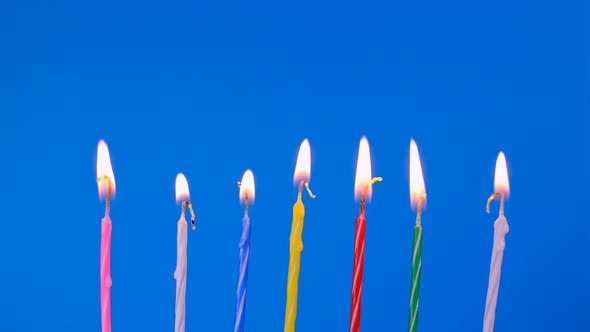 A Set of Birthday Candles Burning Brightly Against a Blue Background