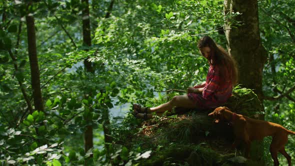 Woman and dog resting in the woods alt