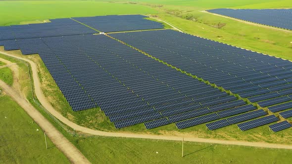 Aerial View of a Solar Panel Field with Rows of Panels Drawing Energy From the Sun at Sunset alt