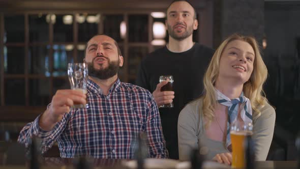 Confident Positive Caucasian Men and Woman Singing National Anthem Watching Match in Pub Indoors alt