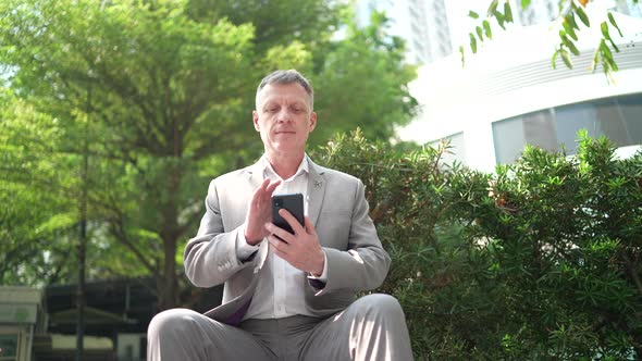 senior professional eco-manager businessman using smartphone device to contact and working alt