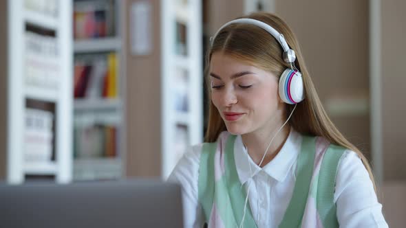 Student Doing Homework on Laptop and Listening to Music with Headphones alt