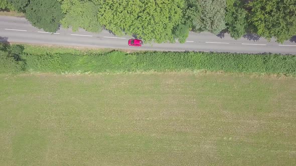 Aerial overhead view of cars driving along a rural road in Devon, England alt