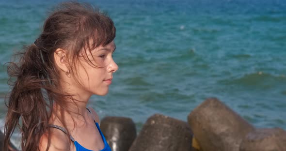 Pensive Girl on Rocky Beach alt
