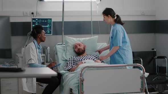 Patient Talking with Medical Doctors While Sitting in Bed During Disease Recovery alt