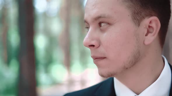 Young Man Standing Among Trees and Looking Afar Portrait alt