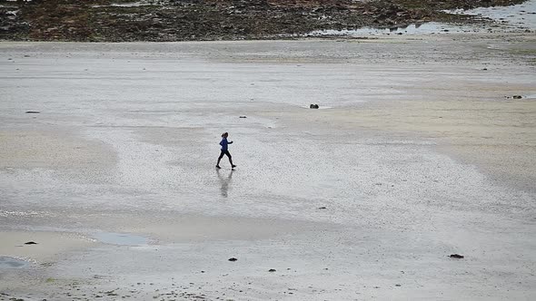 Woman walking alone on a beach