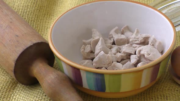 Bowl of baker's yeast on yellow background. Fresh yeast. 