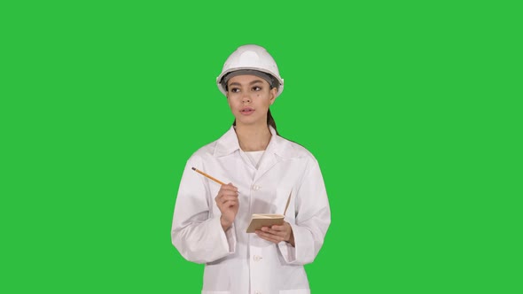 Woman Engineer Writing Checklist Walking on a Green Screen, Chroma Key alt
