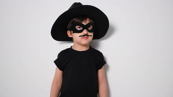 Boy Superhero in a Black Mask and with a Mustache Jumps alt