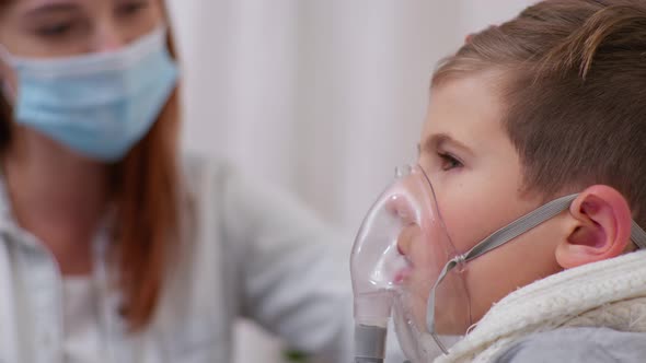 Boy with Symptoms of Dangerous Illness Uses an Inhaler To Prevent Lung Disease at Home on Bed with alt