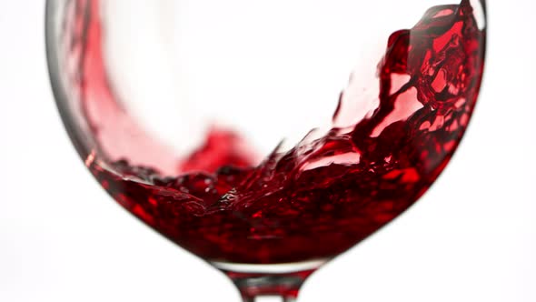 Super Slow Motion Detail Shot of Pouring Red Wine Isolated on White Background at 1000Fps. alt