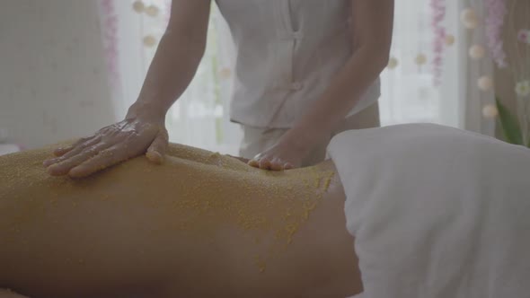 Young Man getting a salt scrub treatment at the spa aromatherapy alt