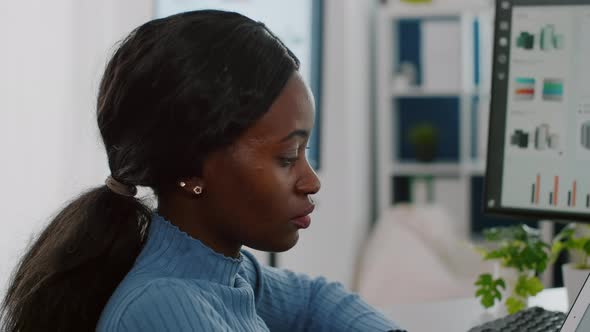 African Invalid Manager Woman Using Pc and Tablet in Same Time alt