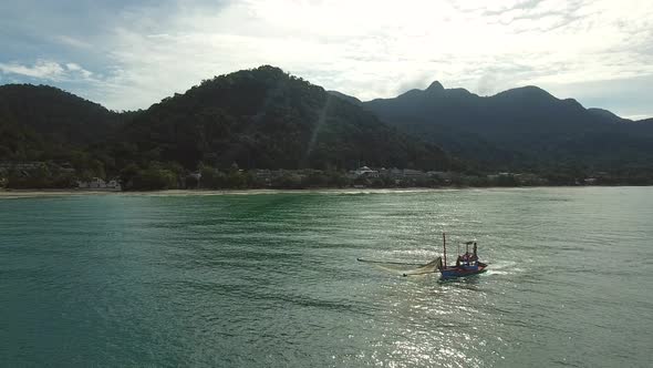 Aerial view of small fishing boat navigating on calm water, Ko Chang, Thailand. alt