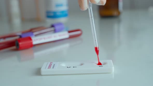 Doctor in Gloves Doing Rapid Test for Viral Disease Dripping Blood on Lab Card Kit Test alt