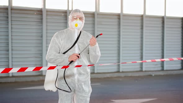 Man Worker Standing Border Line Warning Sign Disinfects Sprays Chemicals on Surface Against alt