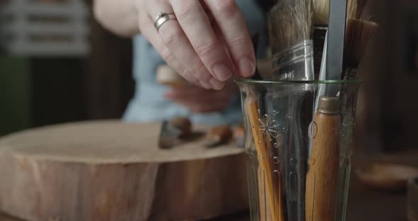 Close-up of Woman Carpenter's Hand Taking a Pencil Out of a Glass with Tools alt