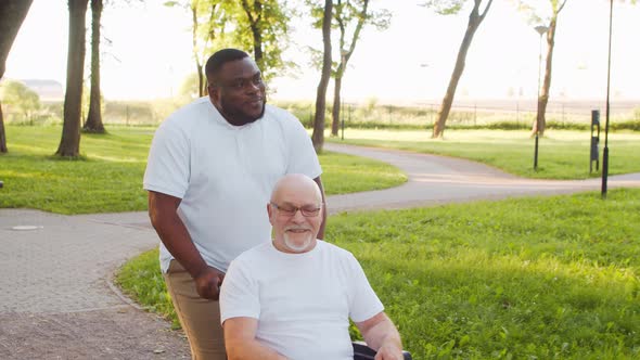 African-American caregiver and old disabled man in a wheelchair. Nurse and patient. alt