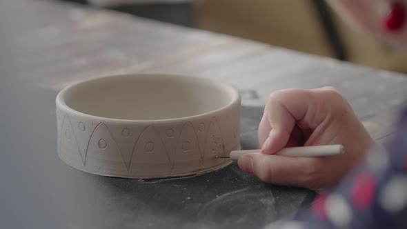 Woman Hands During Painting on Ceramic Plates alt