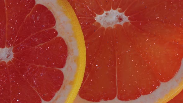 Colorful Red Citrus Fruit Slices of Grapefruit on Rotating Surface  Close Up