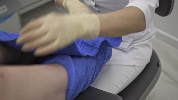 The Doctor Wraps the Patient's Legs in Towels After the Treatment Procedure
