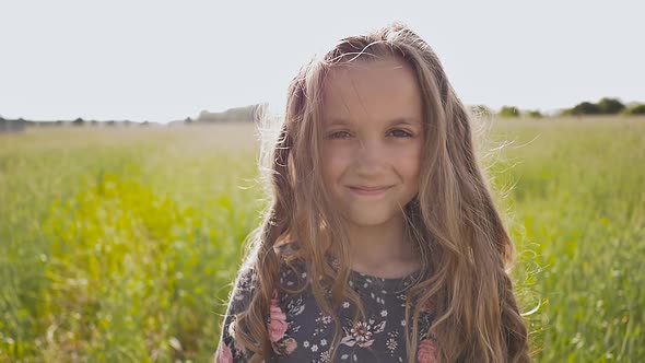 Little Girl Smelling a Daisy Spring Flower in Meadow Field by ...