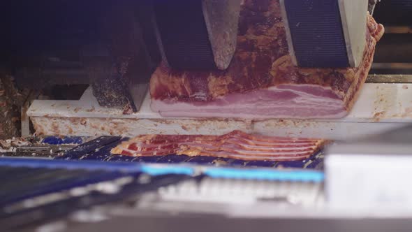 Automatic Industrial Cutter Quickly Cuts Large Pieces of Smoked Pork Bacon Into Thin Strips