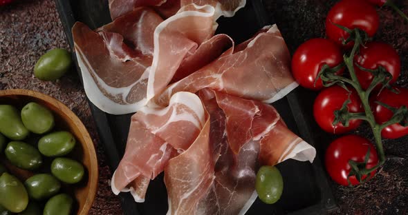 Antipasto with Tomatoes and Olives Rotates on the Table. alt