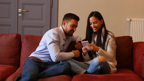 A young couple discussing content on a smartphone	