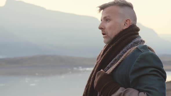 Travelling Man In Scarf Looking Away In Awe alt