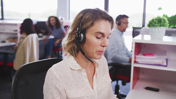 Professional businesswoman talking on phone headset in modern office in slow motion alt