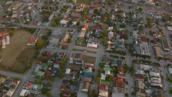 Aerial Descending Footage of Dense Town Development with Family Houses Between Streets alt