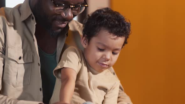 Father helping his son to turn a screw