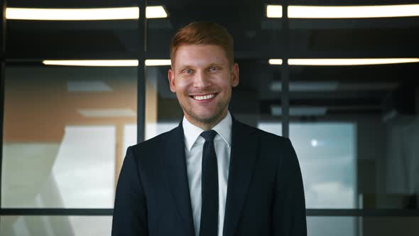 Smiling man in a suit in the office. Businessman looking at camera alt